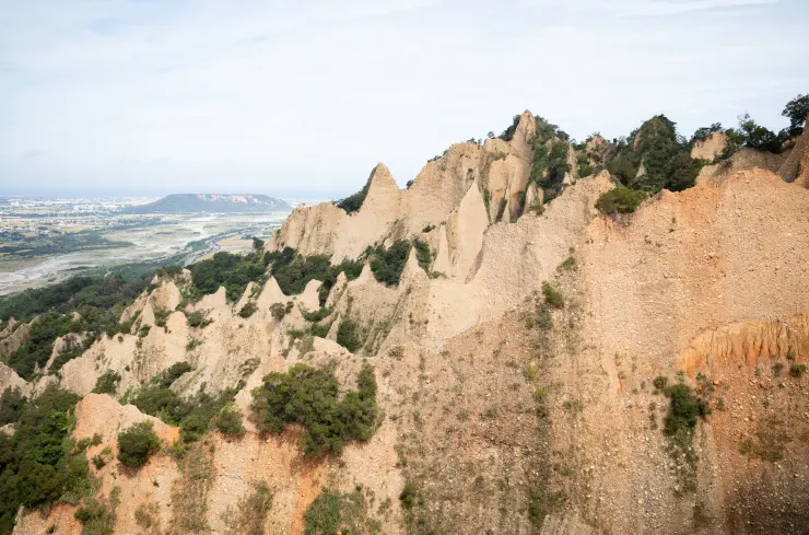 從火炎山猙獰的山壁遠眺大甲名山鐵砧山