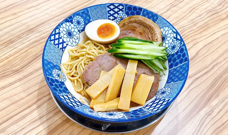 小白拉麵夏季限定乾拌麵全貌，碗內鋪滿叉燒丁、蔥花、筍乾與誘人生蛋黃，視覺豐富澎湃。