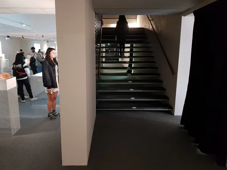 2樓下1樓的動線與4樓下3樓、3樓下2樓的位置完全不同，並且藏於黑色布簾（圖右）之後，很容易繞了一圈找不到正確下樓動線。攝影：UX.Debugger。