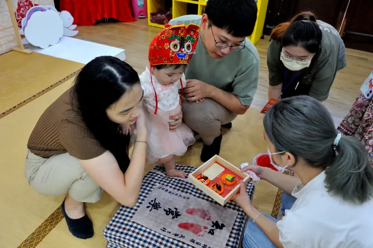 【葫蘆印章算盤，工作人員送來抓周結果證明。】