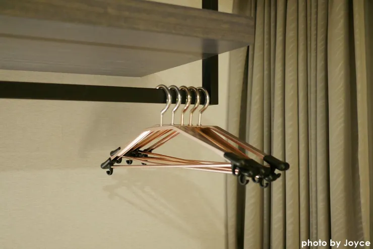 貴妃椅沙發區後方則是書桌，我們後知後覺才發現書桌上方除了有書櫃、還有這個開放式的衣架空間，可以把衣物吊掛在此區。