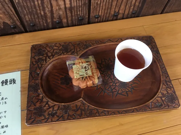 楓葉饅頭及熱茶放在木質托盤上，看起來很有質感