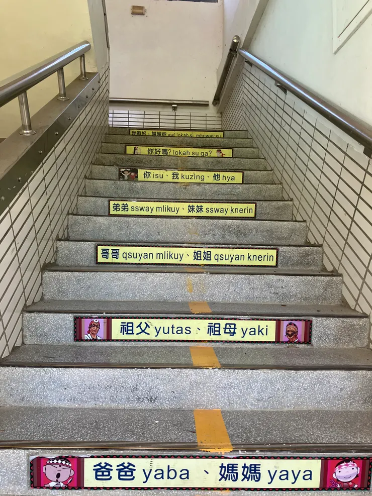 員崠國小的階梯上，貼著華語和泰雅語並陳的單字和句子