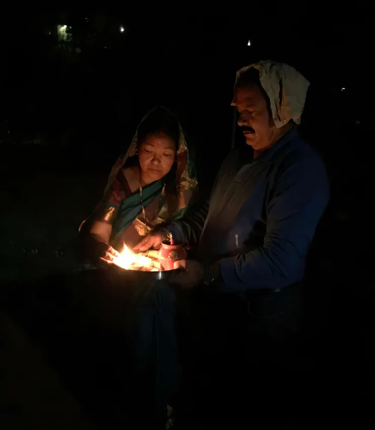 公公與婆婆正在點燈，微光映照下的他們神情安詳，整個屋頂彷彿被溫暖包圍，這一刻的美好與平靜，正是 Karva Chauth 的意義所在。