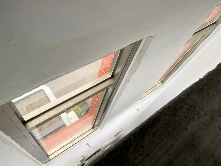 樓梯間並未貼緊牆面，是上下通透的。靠近邊緣往上下看，可以看到長形開窗