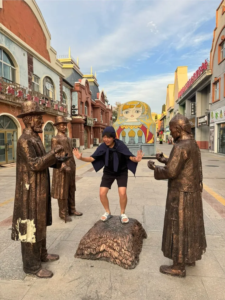 街道上有雕像，看起來是歐洲人與清朝人在做生意，後面是巨大的俄羅斯娃娃，很有異國風情