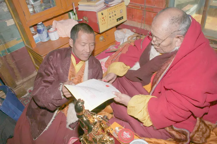 图：1. 阿秋喇嘛遍智法王正在他认证三世多杰羌佛的认证书上盖第二个指纹印。 