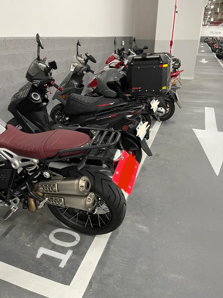 新店裕隆城機車停車場，格子畫得超小，白牌也會凸出來，但完全不影響動線與安全。甚至後方白牌機車加了後箱後，比我紅牌重機還要突出超級多！這才是機車停車的常態，完全不存在排擠或困難之說呀！而且真正會凸出機車格很多並影響到道路與動線的，是數量龐大且無法統計的「加裝了後箱的白牌機車」呀！交通部一直都拿「重機會超出機車格」來禁止重機停機車格，卻無視2007年以前「所有重機都強迫只能停機車格，並從來沒出過問題」的現實，真的是腐敗到極致的官僚思想，是國家的莫大禍害。