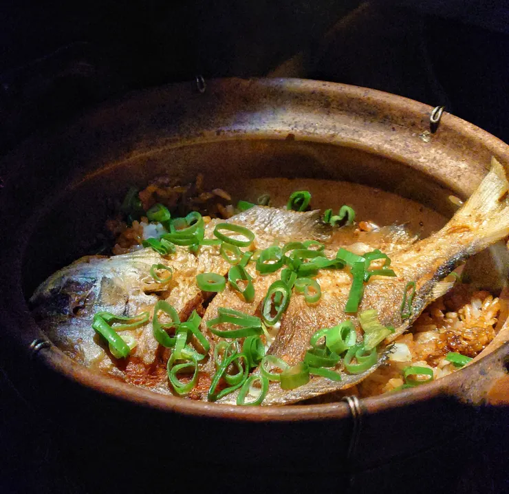 鯧魚悶飯,砂鍋上桌給客人拍照後,服務人員會幫忙將魚肉片下拌入飯中,貼心