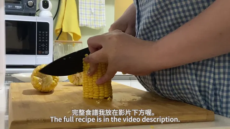 用刀子順著玉米芯方向小心地切下玉米粒
