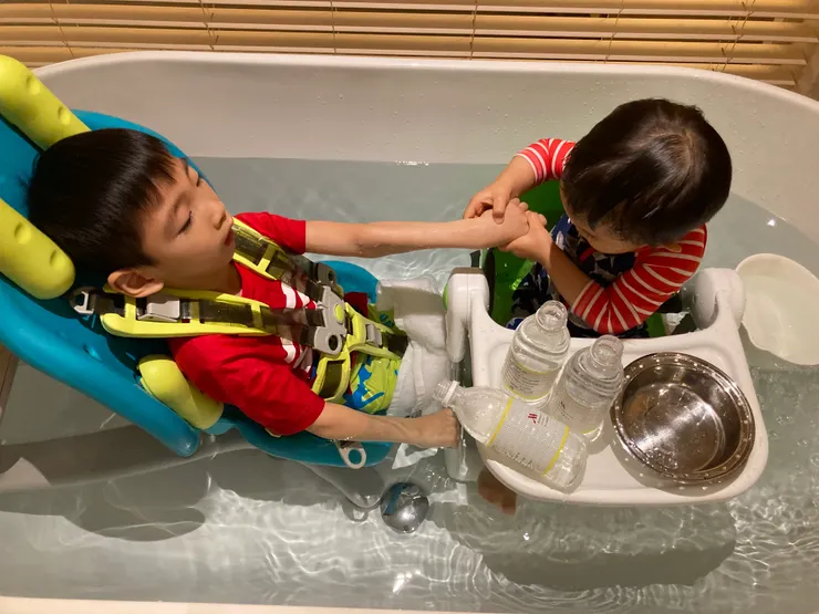 弟弟牽著祐的手一起玩。