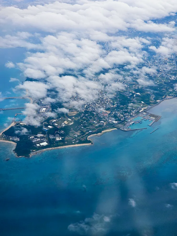 透過舷窗，沖繩的雲與海，是藍色畫紙上暈開的棉絮。