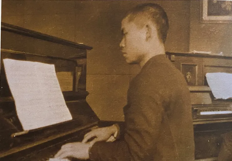 1943年20歲的陳奇祿在東京彈鋼琴的情景（圖片翻攝自《神手奇畫》，陳國儀提供）