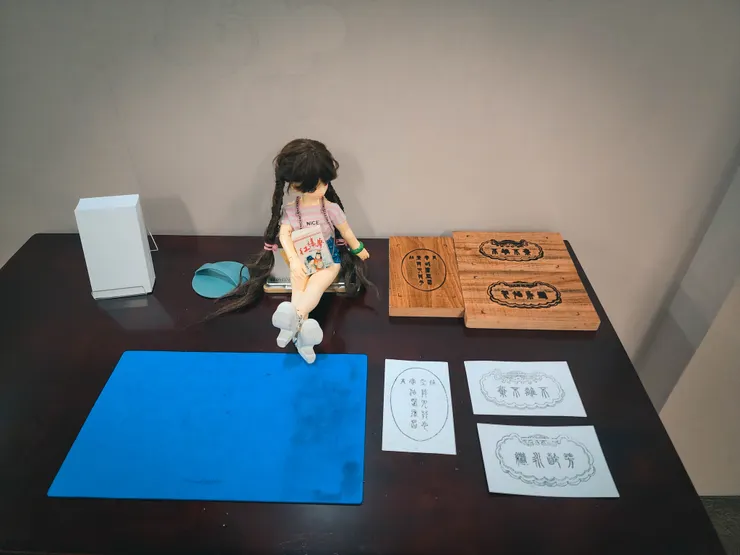 紅樓印記：  這邊是使用拓印的方式，將木刻板沾滿墨後，白紙照記號放上，使用旁邊的馬連(版畫用具) 以平均按壓施力，就可以得到完美的拓印．  通靈寶玉上頭的字（賈寶玉出生時含在口裏的玉）：莫失莫忘，仙壽恆昌．  金鎖上鑿的字(寶釵身上的金器) ：不離不棄．芳齡永繼．  這兩句都是茫茫大士所示(虛擬的神仙人物)  意思都是吉祥話：長命百歲