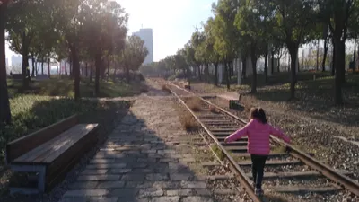 小女孩走在廢棄軌道上