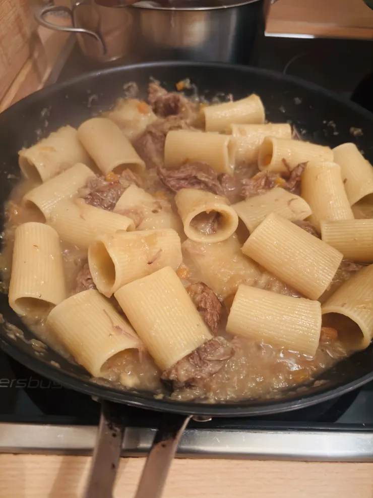 在鍋裡混合麵條和醬汁是必須的動作