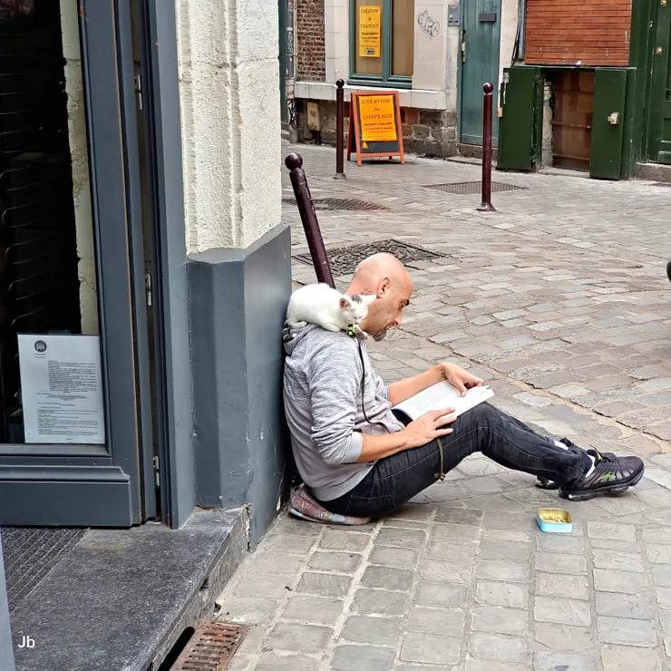 【老城區建築典雅商號應有盡有，侄女品味高帶訪店家俱為上選！Célestin精釀啤酒店門前，這位老兄是乞者或街頭藝人我搞不清楚，總之帶隻貓坐在這裡讀書就有人打賞。】