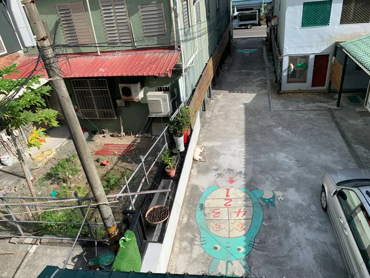 從窗戶往外看的景色，店狗雪球正在做日光浴，龍貓左邊正在曬的是黑蒜頭。