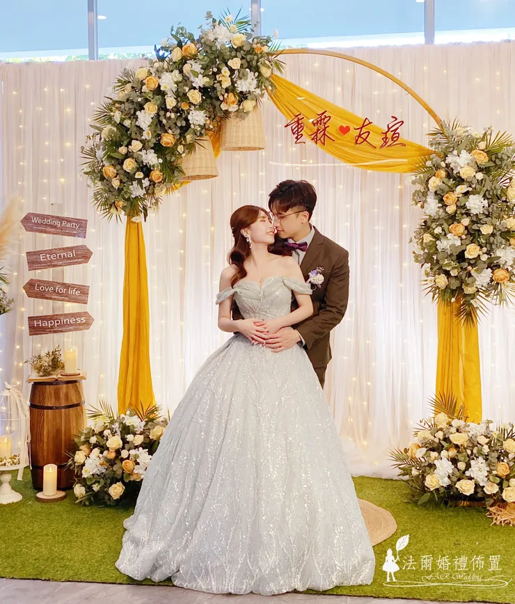 幸福檸檬黃婚禮佈置 @ 台南亞果薈 安妃屈蒂餐廳  在台南的海風與陽光中，亞果薈 安妃屈蒂餐廳見證了無數浪漫時刻。這場以 **「幸福檸檬黃」**為主題的婚禮佈置，運用溫暖明亮的檸檬黃色調，搭配歐式花環與羽毛芒草，營造出陽光般的幸福氛圍。  金黃色的拱門，點綴著飽滿的白玫瑰與香檳玫瑰，配上木桶、燈串與鄉村風擺飾，讓每個角落都成為新人與賓客的拍照打卡點。  「幸福檸檬黃」不只是婚禮顏色，更是一種情感的溫度——象徵喜悅、溫暖與甜蜜。每一次呈現都經過專業團隊的精準擺設，確保現場與範例一致，讓新人在籌備婚禮時更安心。