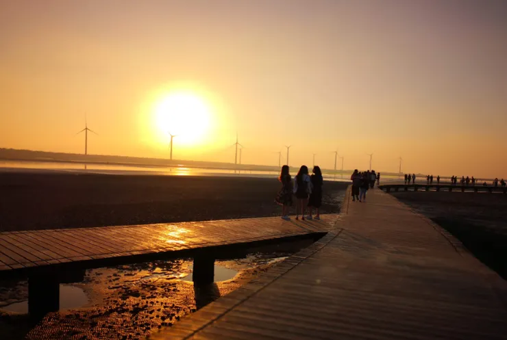 站在水裡拍剪影：讓夕陽在人物後方，手機點選太陽位置曝光，人物自動變成超有質感的剪影。