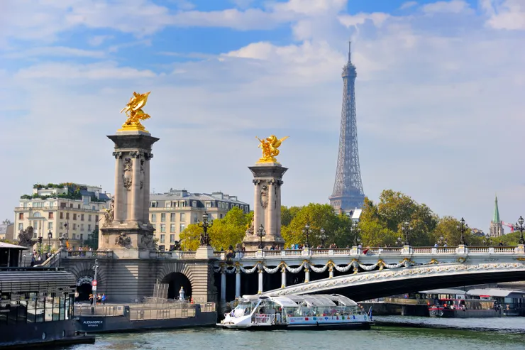 【船行河中左顧右盼指點建築橋樑！前景為裝飾華麗的亞歷山大三世橋（Pont Alexandre III），背景有艾菲爾鐵塔（Eiffel Tower）。該橋為巴黎最華麗的橋樑，於1892年由俄國沙皇尼古拉二世作為法俄親善的禮物贈送給法國，並以其父亞歷山大三世之名命名。】