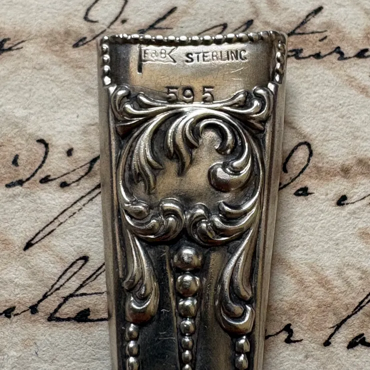一面有打印旗幟圖樣的”F&B “ 跟 標示純銀材質的”STERLING”