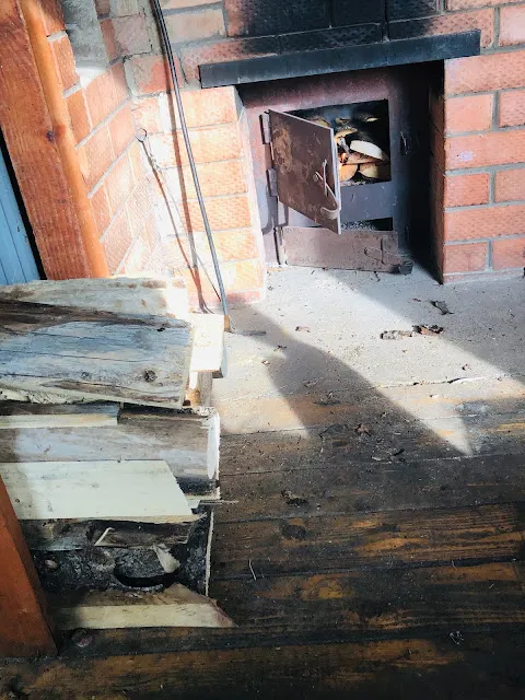 旁邊的火爐裡燃燒著白樺木，火爐的上方，正在加熱一顆大石頭。