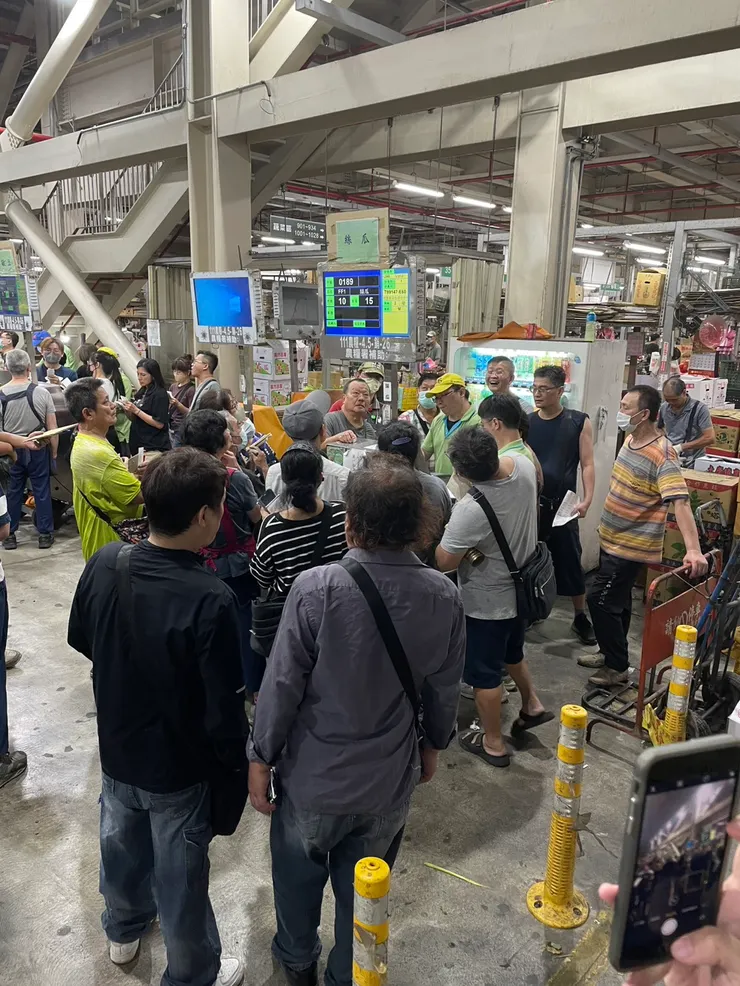 一群人為在拍賣台旁邊，聽著價格