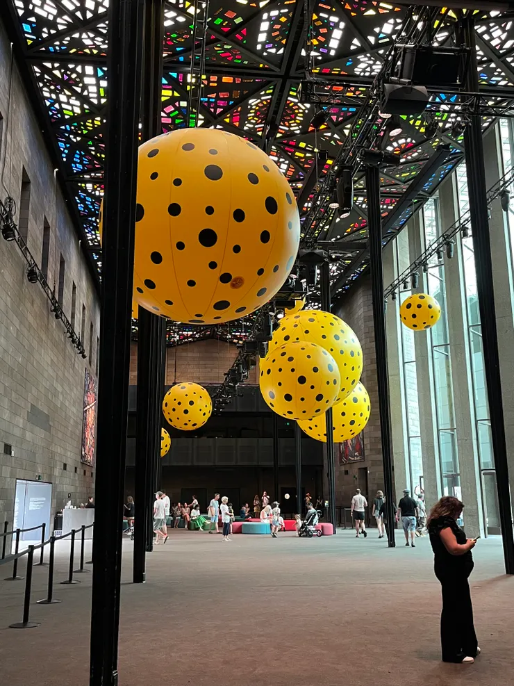 世界最大的彩繪玻璃天花板,懸掛的黃色球也是草間彌生特展布置之一