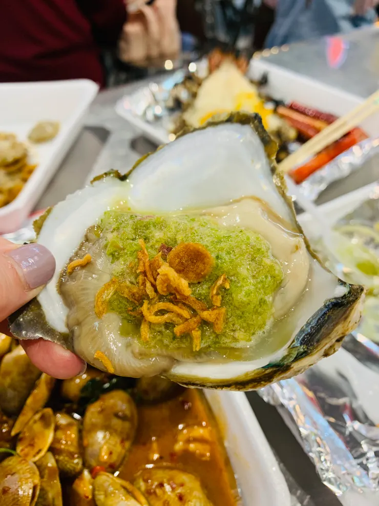 生蠔1顆80株，搭配綠色海鮮醬，炸蒜頭，超好吃。綠色海鮮醬是靈魂。