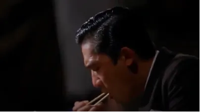 鏡頭緩緩向右移動，呈現周慕雲在麵攤吃麵的場景。（此鏡頭移動的方式，有別於直線敘事，暗示周慕雲於不同時間點皆一個人在麵攤晚餐的情況）