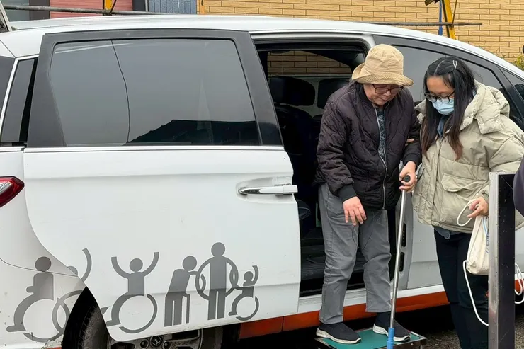 （圖說：居住在宜蘭縣大同鄉南山村的寶玉阿嬤(左)，因為有了交通車服務後，得以來到伊甸宜蘭縣私立茂安頤福社區長照機構接受服務。）