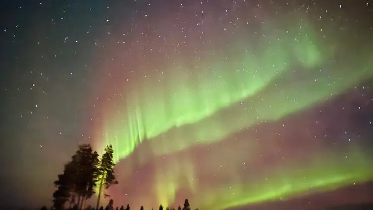 極光悄悄劃過夜空，紅、綠、紫光絲在星星之間流轉，好像時間都慢了下來。