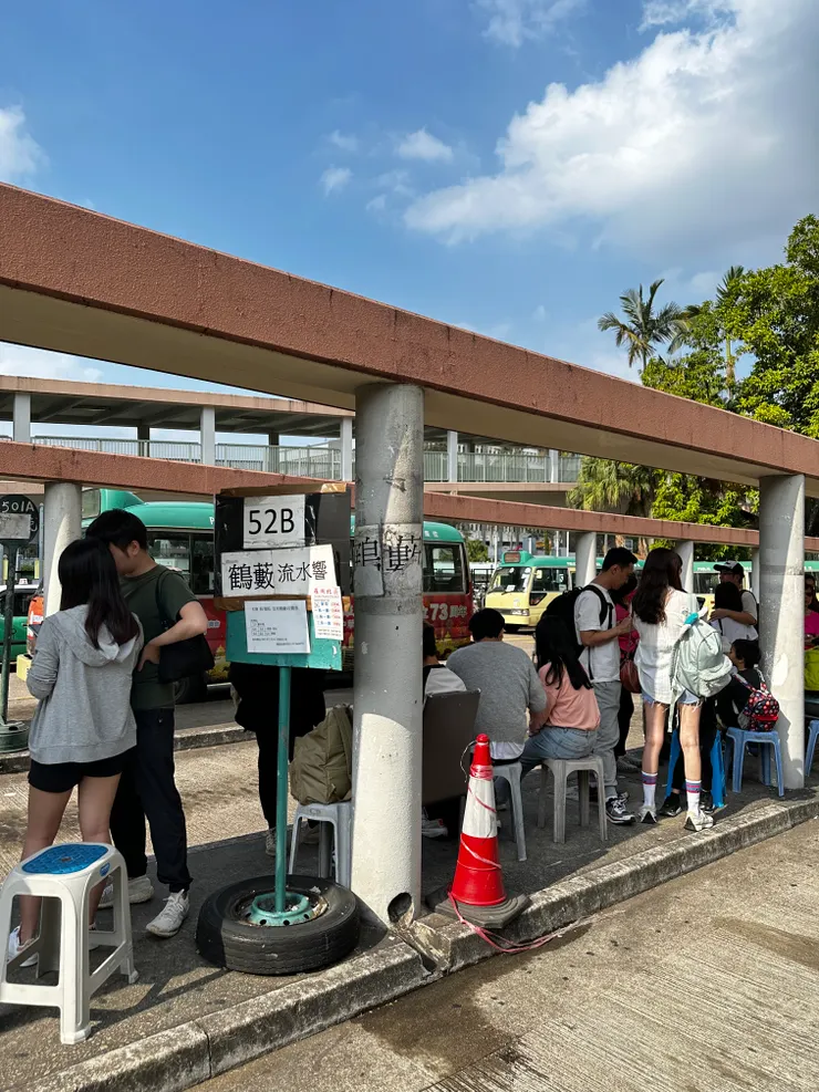 看到車站牌52B，跟着人龍排隊乘搭便可以