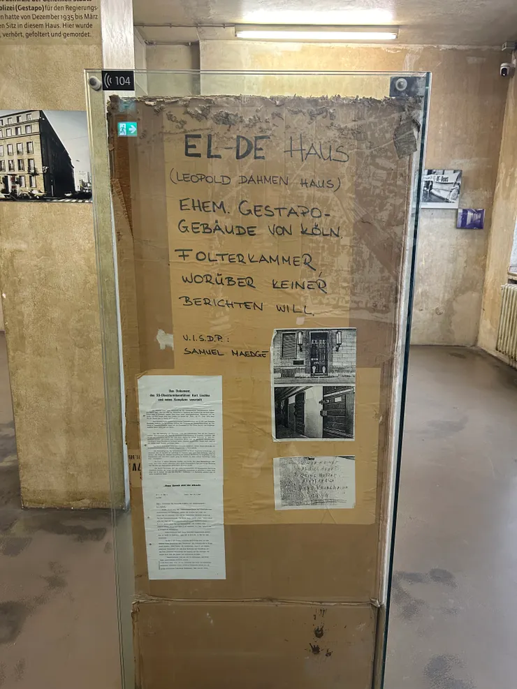 Sammy Maedge 倡議時背的告示牌，告訴大眾 EL-DE Haus 曾經的歷史。