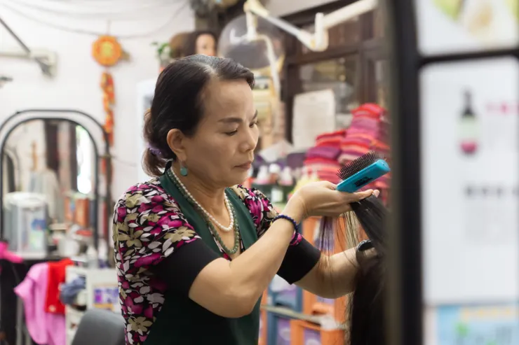 老闆娘專心地為客人梳理頭髮。