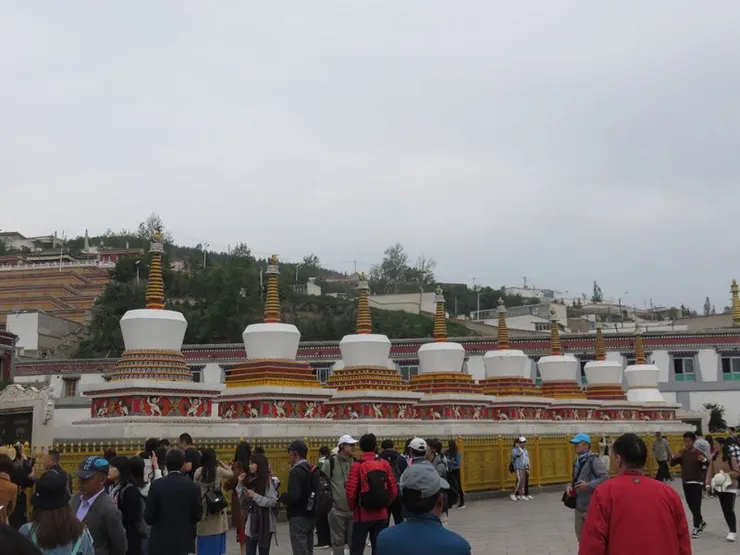 「在停車場下車購票進入大門，有一瞬間，我恍惚間覺得像是穿越了一般，滿眼的絳紅色，*滿耳的梵音*，進入大殿，有人誦經、有人轉經、有人打坐、有人跪拜. …..在塔爾寺，尋找心靈的依託。」仿「驢友」式「崇高」caption。