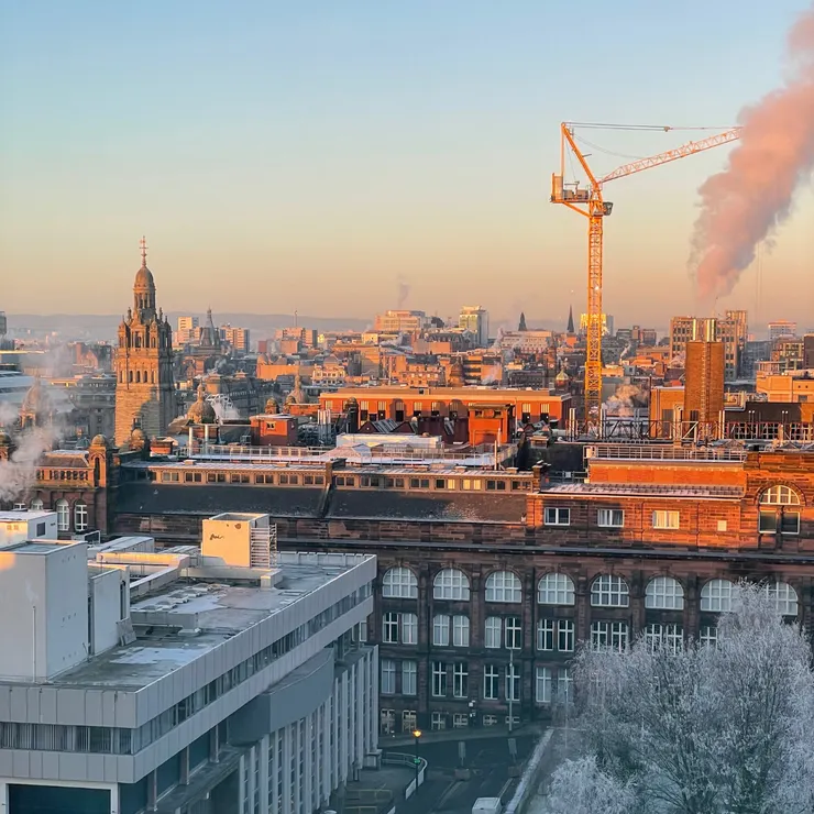 冬天的溫和夕陽讓建築都染上一層棕橘色，對映著霜白色的樹叢，形成有趣的冬日景象。