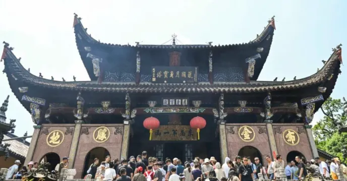 肉身宮的正面建築,雄偉的屋頂裝飾著精美的雕刻和顯眼的紅燈籠,前方擠滿了來訪的遊客,氣氛熱鬧非凡。