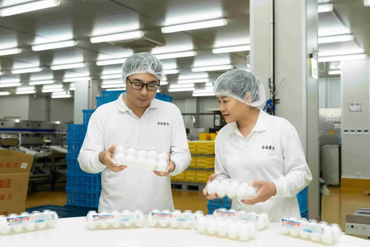 圖說：臺南蛋品總經理陳昭延（左）與品管課長戴月娥（右）於洗選線上嚴密抽檢，從源頭到成品層層審核，實踐對消費者餐桌安全的健康承諾。（資料來源：臺南蛋品）