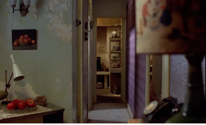 圖5&nbsp;鏡頭停留在主角租屋處的走廊， 左側牆上掛著以水果為主題的靜物畫， 而在畫作前方桌上即擺放著實體水果盤