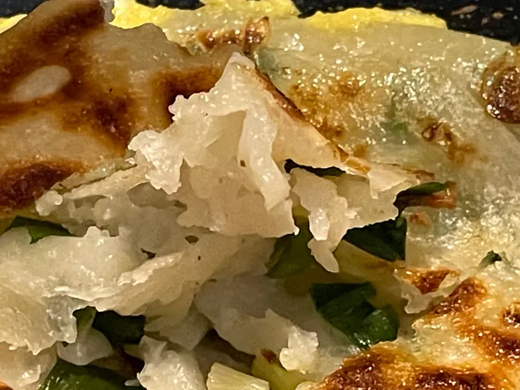 翻開蔥油餅麵皮就會看到非常明顯的宜蘭三星蔥，不像超市買到的都是生冷乾燥的蔥片