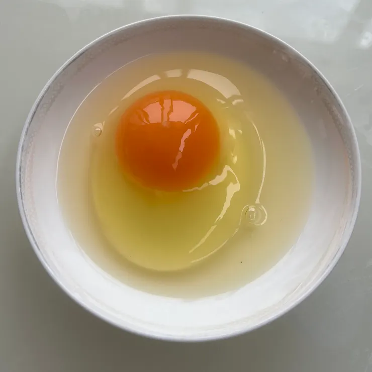 一顆新鮮的雞蛋，蛋白的部份會有很明顯地分層，蛋黃及中心蛋白也會非常挺立