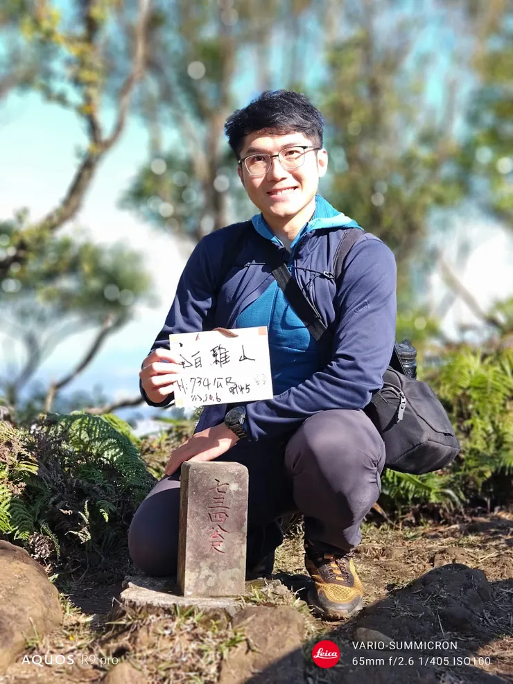 白雞山登頂照。相對於全手動的M10-R根本不可能丟給路人幫忙拍照,手機方便太多了。在郊山複雜的場景中,人像模式雖有助於凸顯主體,效果也比之前用過的Sense 8好,但依然看得到一點運算痕跡。或許靠軟體的更新與AI的訓練,效果會越來越好。(SHARP AQUOS R9 pro,65mm)