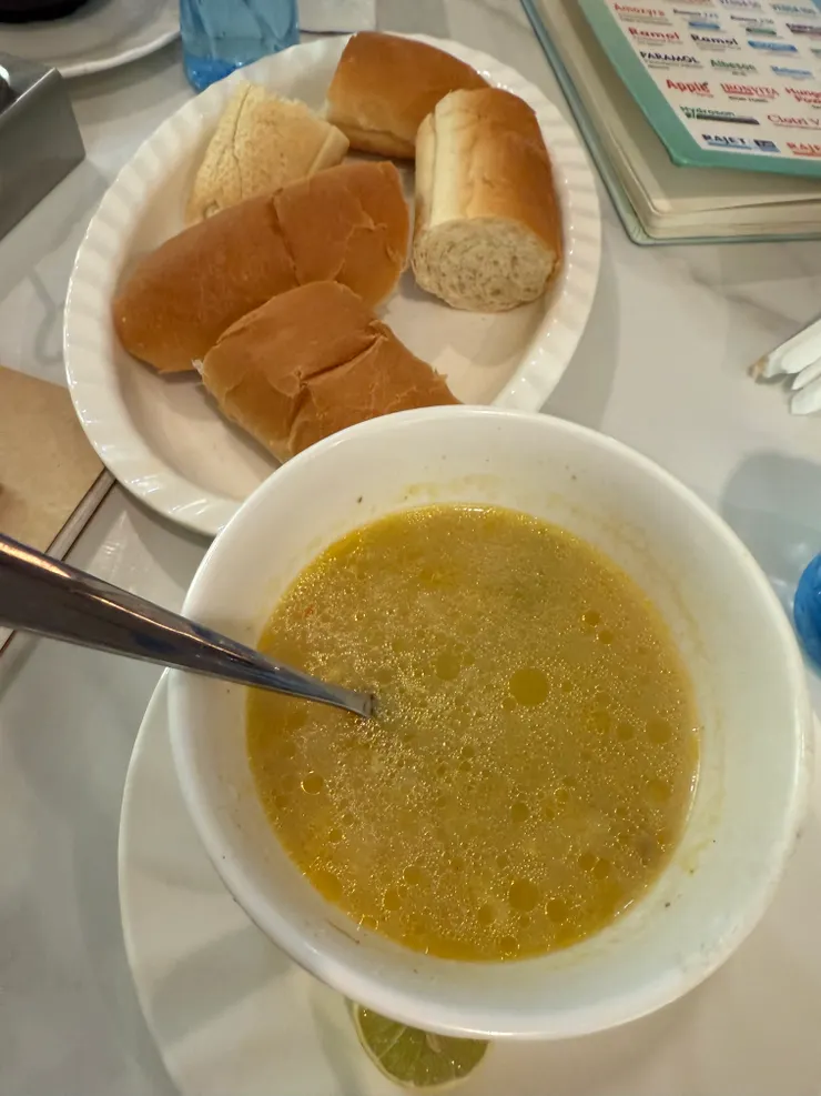 搭配的清湯，裡面有肉末，加柑橘類水果、Somalia 辣醬很提味，配著麵包一起吃