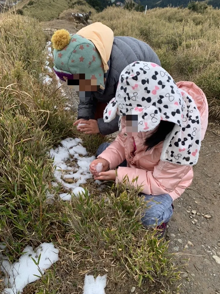 兩個孩子邊走邊玩雪。