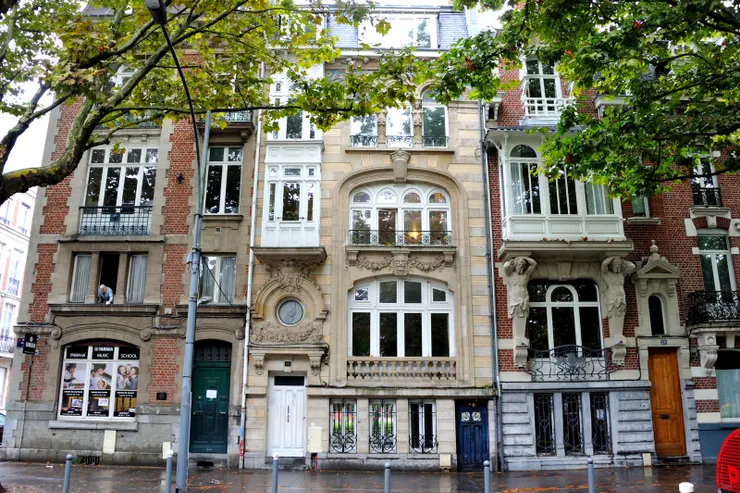 【繞一圈回家！街景之一，典雅的住宅大樓。二樓左有位白髮老婦探出半身。】