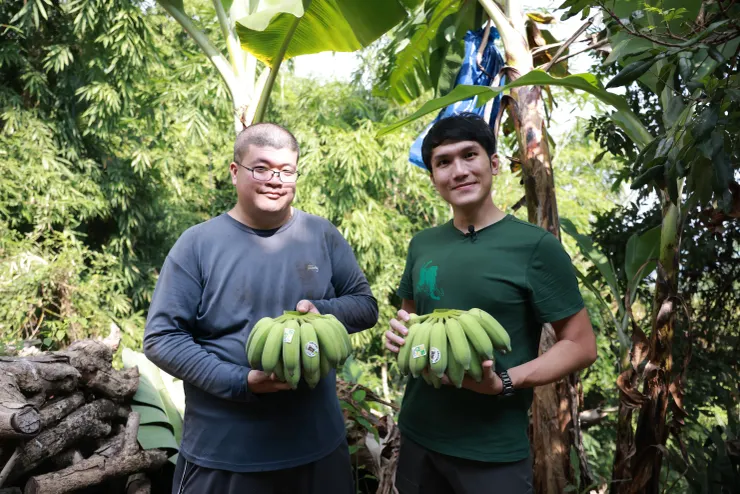 左邊就是中寮石虎友善農作的蕉農－家樂福石虎山蕉的生產者田懷生。仔細看我們手上的香蕉，圓形那個中間有一隻石虎頭的，才是正港的官方石虎友善農作標章喔！