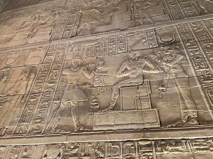 伊西斯的頭飾被替換為哈托爾的： 一對母牛角中間有一日盤。