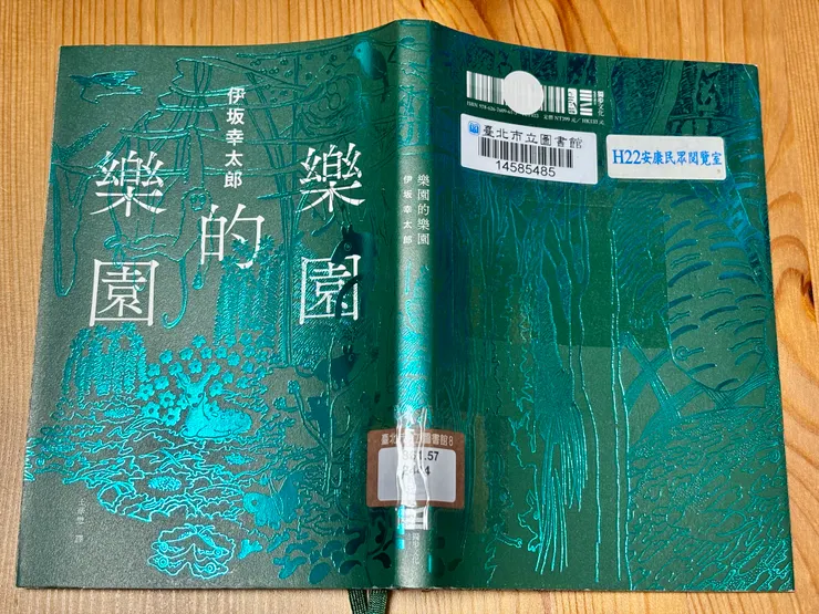 書封展開後的樣貌。封底延伸出樹影與枝條，像是樂園的另一面。